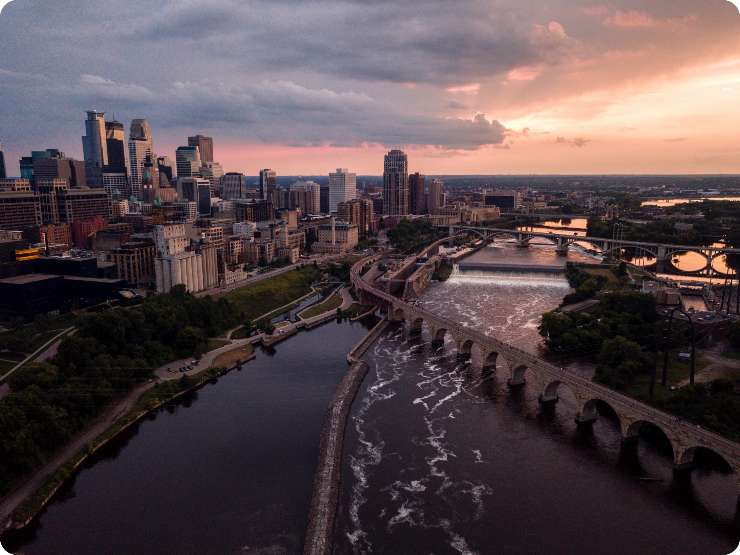 a picture of the Minneapolis skyline facing west at dusk taken above the Mississippi River