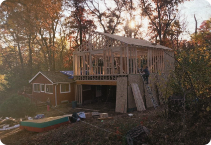 a wood frame addition being constructed by Right Away Construction in the country-side of Minnesota in the late 1990's shows a partially raised frame next to the original home