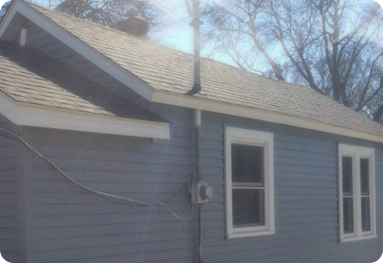 the side of a home remodeled with a new roof and new siding from the 2000's