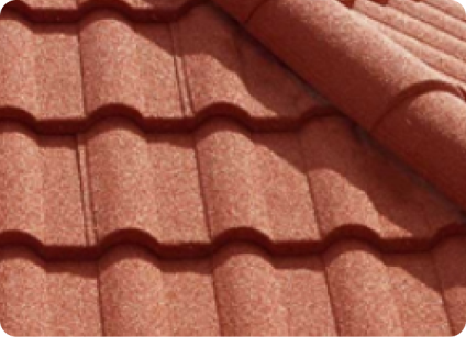 a close-up of a red stone coated steel roof showing the field material and the ridge cap